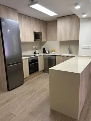 a large kitchen with a refrigerator and a counter at Lorenzo in Benaguacil