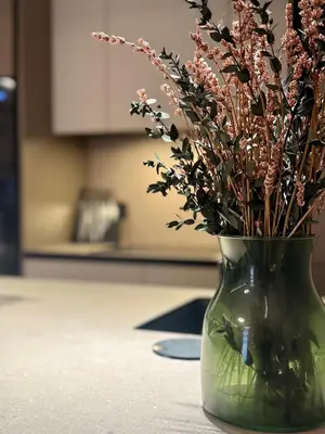 a green vase with flowers in it on a table at Sunny Waves Apartment in Cullera