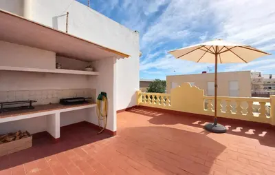 a patio with an umbrella on a balcony at 4 Bedroom Stunning Home In Sueca in Sueca