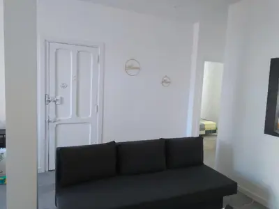 a black couch in a white room with a door at La Corona de Valencia in Valencia