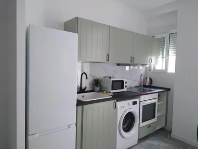 a kitchen with a white refrigerator and a washing machine at La Corona de Valencia in Valencia