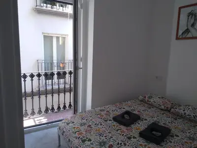 a bedroom with a bed with two black shoes on it at La Corona de Valencia in Valencia