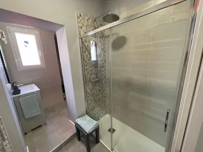a glass shower in a bathroom with a stool at Cabañal Flat, Wi-Fi & AACC in Valencia