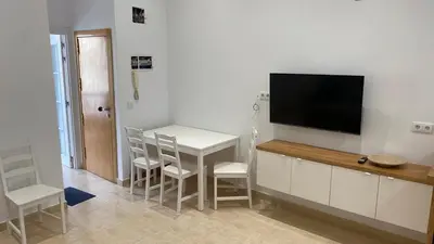 a living room with a table and a flat screen tv at Cabanyal Apartment in Valencia