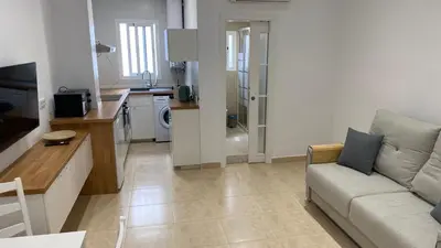 a living room with a couch and a kitchen at Cabanyal Apartment in Valencia