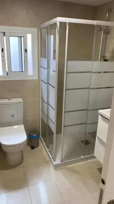 a bathroom with a toilet and a glass shower at Cabanyal Apartment in Valencia