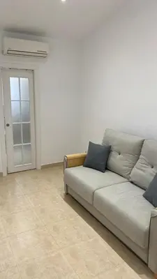 a living room with a couch and a door at Cabanyal Apartment in Valencia