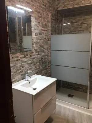 a bathroom with a white sink and a brick wall at Charming beachfront apartment in Puerto de Sagunto