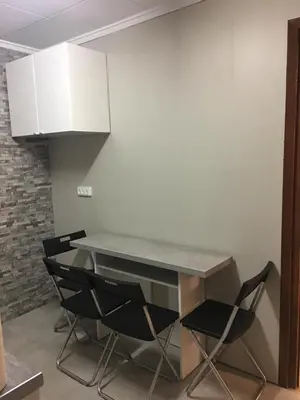 a table and chairs in a kitchen with white cabinets at Charming beachfront apartment in Puerto de Sagunto
