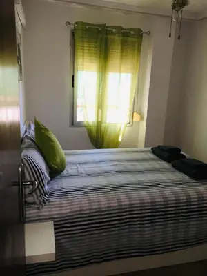 a bedroom with a large bed with a window at Charming beachfront apartment in Puerto de Sagunto