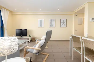 a living room with chairs and a table and a tv at Patacona Azud in Valencia