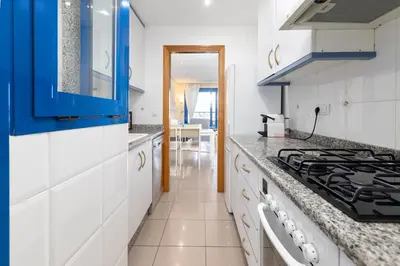 a kitchen with white counters and blue cabinets at Patacona Azud in Valencia