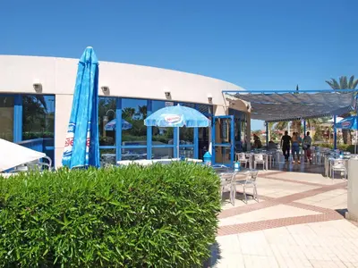 a patio with umbrellas and tables and chairs and a building at Patacona Azud in Valencia