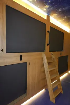 a room with two large screens and a wooden chair at Joaquin Sorolla Pod Hostel in Valencia