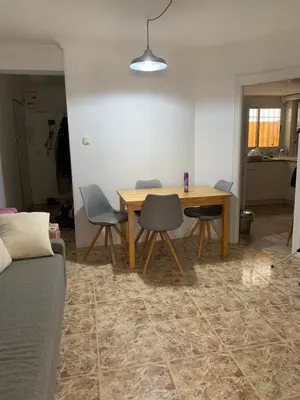 a living room with a wooden table and chairs at Habitacion individual cerca del puerto in Valencia