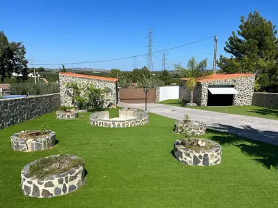 a garden with four stone planters in the grass at Villa Noelia in Turís