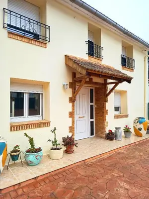 a white living room with a table and yellow chairs at La Llar del Magraner in Barraca de Aguas Vivas