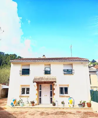 a white house with a white door and windows at La Llar del Magraner in Barraca de Aguas Vivas