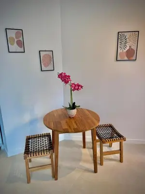 a wooden table with a vase of flowers on it next to two chairs at Glamour Suite1 next to Plaza de España in Valencia