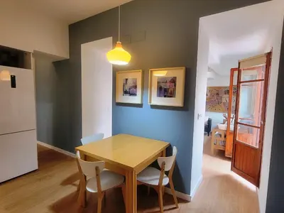 a kitchen and dining room with a wooden table and chairs at Casa ALFANG in Torrent