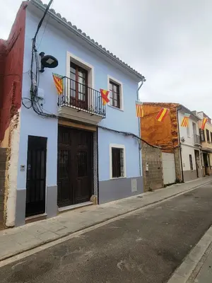 a blue and white building with flags on a street at Casa ALFANG in Torrent