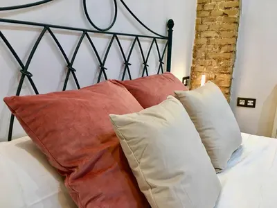 a bed with red and white pillows on it at Historic city center in Valencia