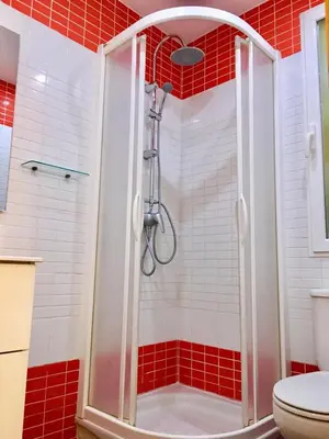 a shower in a bathroom with red and white tiles at Historic city center in Valencia