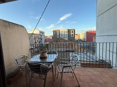 a living room with a couch and a table and chairs at Kiwi Penthouses in Valencia