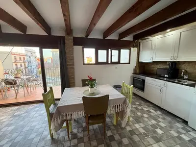 a kitchen with a wooden table and chairs in a kitchen at Kiwi Penthouses in Valencia