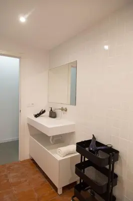 a white bathroom with a sink and a mirror at Can Turia in Valencia