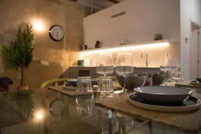 a kitchen with a table with wine glasses and a clock at Can Turia in Valencia