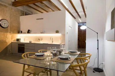 a dining room with a table and chairs in a kitchen at Can Turia in Valencia