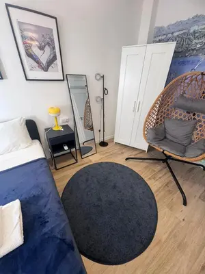 a bedroom with a bed and a chair and a rug at Large New House with Terraces and Air Conditioning in Cullera