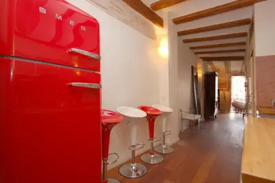 a red refrigerator in a room with bar stools at Beds & Breaks Ravel I in Valencia