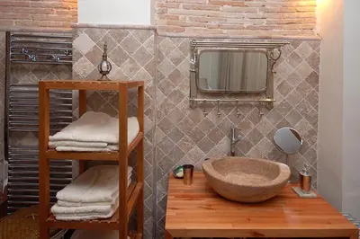 a bathroom with a stone sink and a mirror at Beds & Breaks Ravel I in Valencia