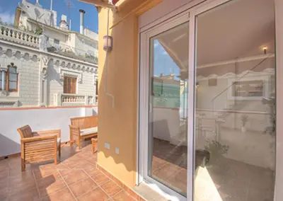 a white bedroom with a white bed and a table at Beds & Breaks Pergolesi in Valencia