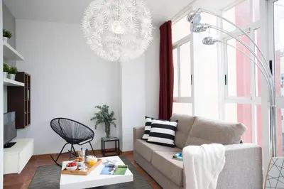 a living room with a couch and a chandelier at SingularStays Botanico29 in Valencia