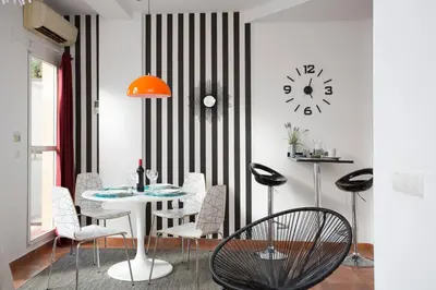 a dining room with a table and chairs and a clock at SingularStays Botanico29 in Valencia