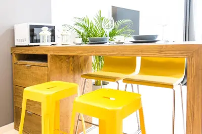 a kitchen with yellow stools at a wooden table at Total Valencia Old City Luxury in Valencia