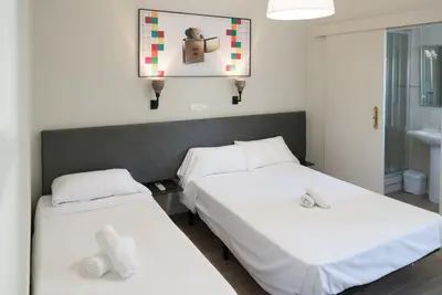 two beds in a room with white sheets at NWT Central Station Valencia in Valencia