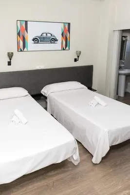two beds in a room with a car on the wall at NWT Central Station Valencia in Valencia
