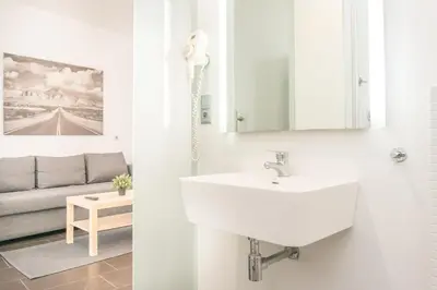 a white bathroom with a sink and a couch at Valencia Luxury - Boutique Center in Valencia