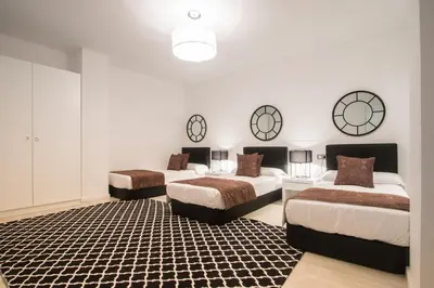 two beds in a room with three clocks on the wall at Valencia Luxury - Boutique Center in Valencia