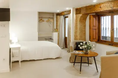 a bedroom with a bed and a table with flowers at Host & Home in Valencia