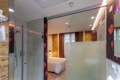 a bathroom with a glass door leading to a bedroom at Host & Home in Valencia