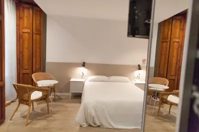 a bedroom with a large white bed and chairs at Host & Home in Valencia