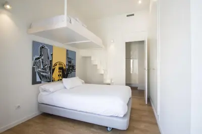 a white bedroom with a white bed and stairs at Valencia Luxury - Boutique Redonda in Valencia