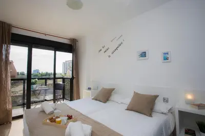a bedroom with a white bed and a large window at SingularStays Artes in Valencia