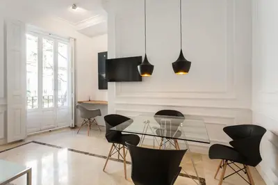 a dining room with a glass table and chairs at Baron Suites Reina in Valencia
