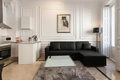 a living room with a black couch and a table at Baron Suites Reina in Valencia